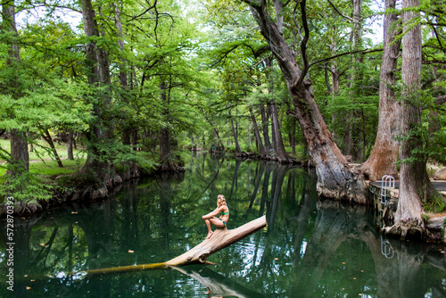 A young woman enjoys a calm swimming hole, the Blue Hole, near Wimberley, Texas. photo