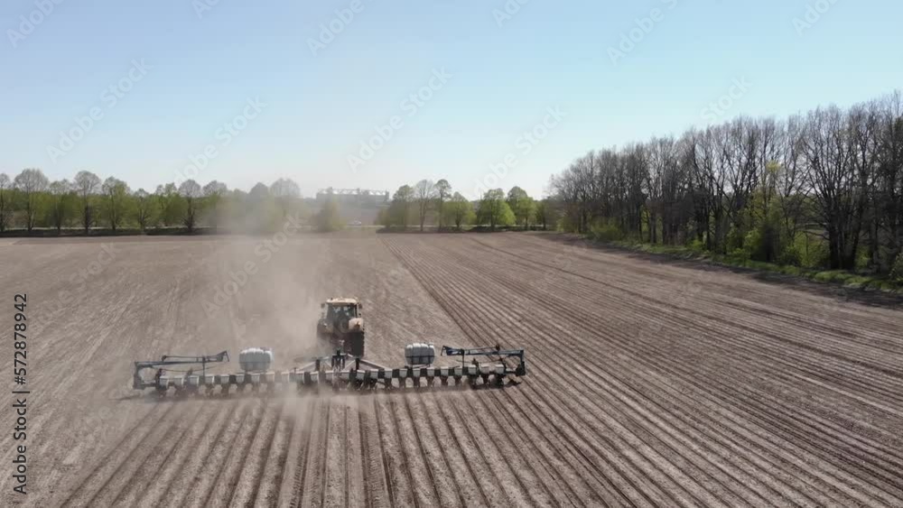 Big yellow tractor planting corn in Ukraine. Tractor working on the field