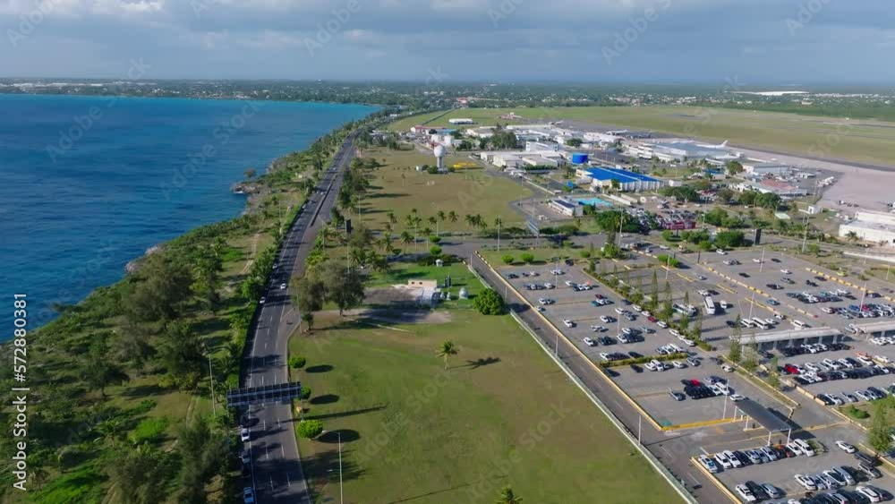 Aerial flight over highway with traffic and parking area of Las Américas International Airport during sunny day on Dominican Republic Aerial flight over highway with traffic and parking area of Las Américas International Airport during sunny day on Dominican Republic