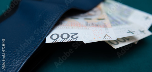 Polish banknotes in a wallet on a green background. Background showing the Polish economy and economy