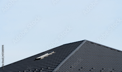 A corrugated metal profile roof for a house with a skylight. Modern roof made of metal
