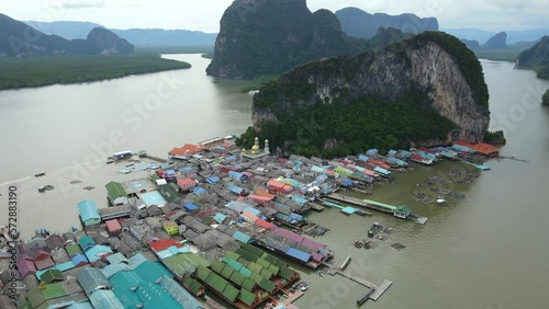 Aerial drone view flying over the floating fishing village at Ko Panyi (or Koh Panyee) one of travel destination in Phang Nga Bay, Phang Nga province, Thailand. 4K footage video