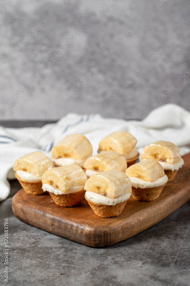 Banana tartlet. Delicious tartlet dessert on wood serving board. close up Banana tartlet. Delicious tartlet dessert on wood serving board. close up