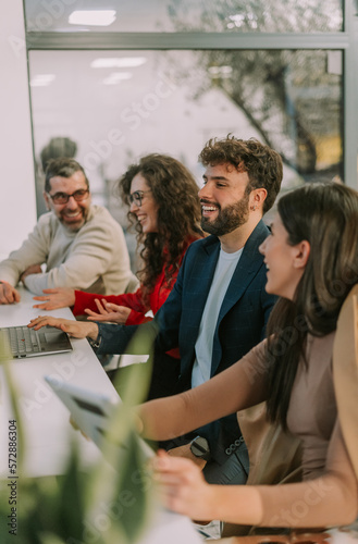 Middle-aged manager joking with his junior colleagues while working together with them