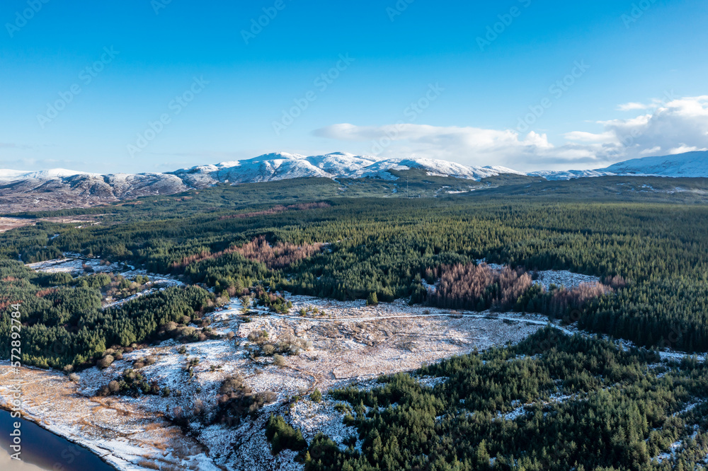 Aerial view of snow covered Gweebarra River between Doochary and Lettermacaward in Donegal - Ireland - The site of the new Cloughercor wind farm in the background