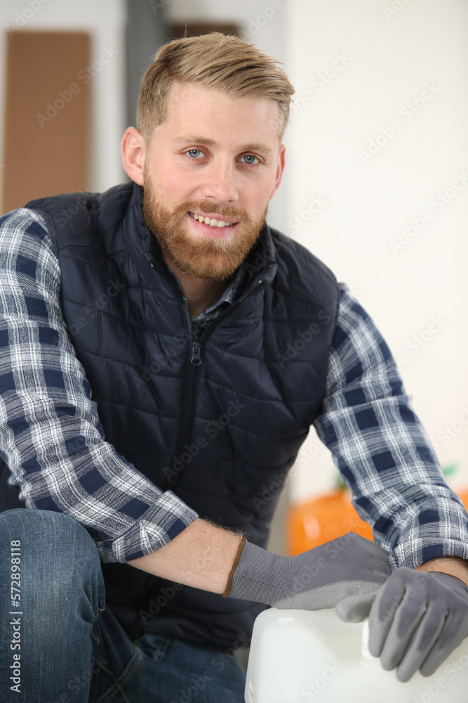 workman wearing gloves to open a plastic container workman wearing gloves to open a plastic container