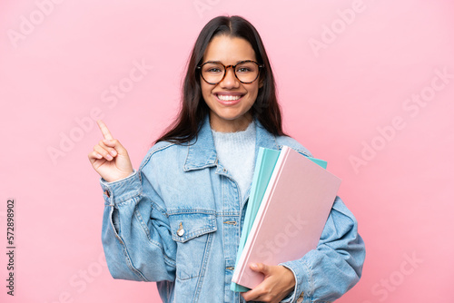 Young student Colombian woman isolated on pink background showing and lifting a finger in sign of the best