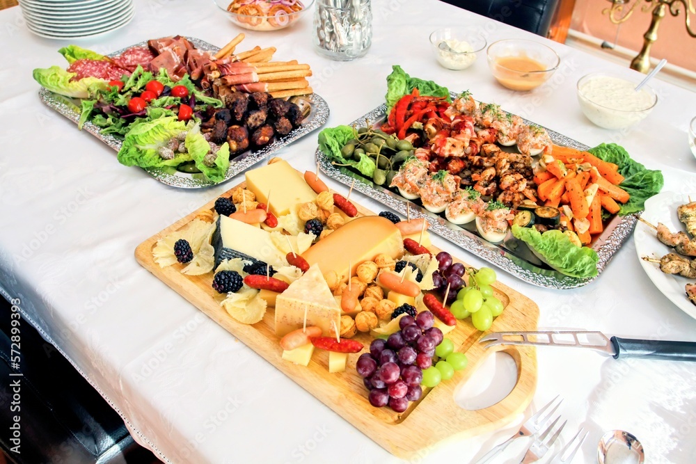 Gedeckter Tisch mit Buffet, leckere Vorspeisenplatten mit Antipasti und Häppchen Gedeckter Tisch mit Buffet, leckere Vorspeisenplatten mit Antipasti und Häppchen