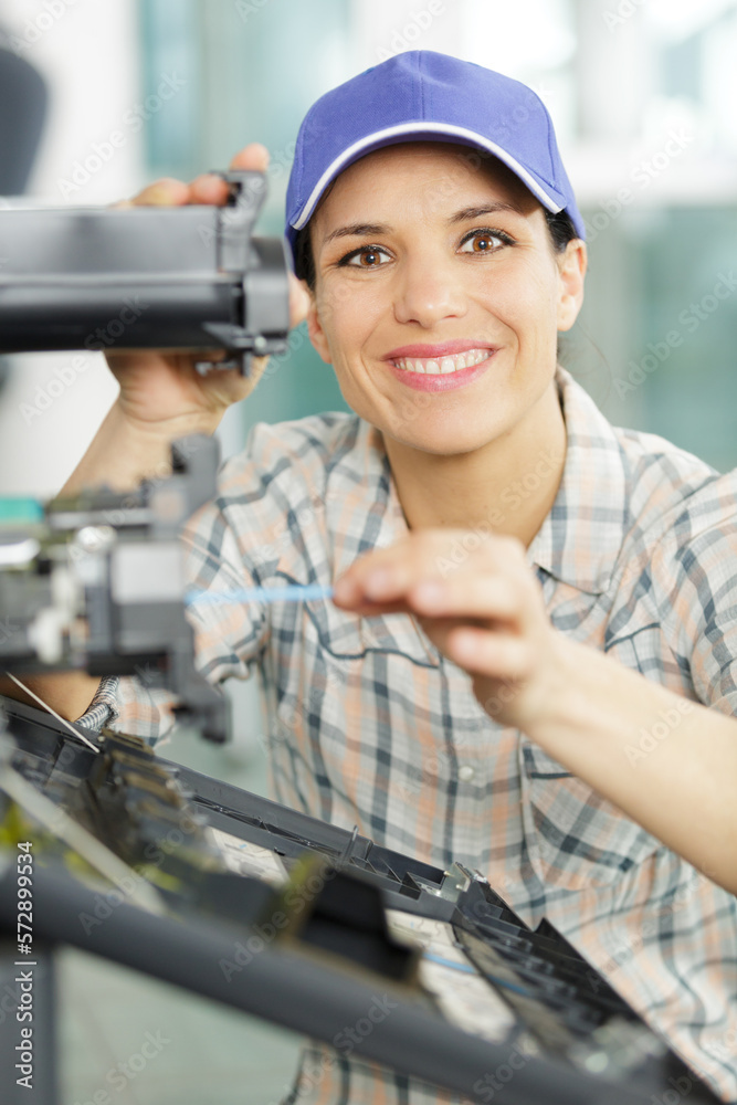 happy female electrician fixing an unit happy female electrician fixing an unit