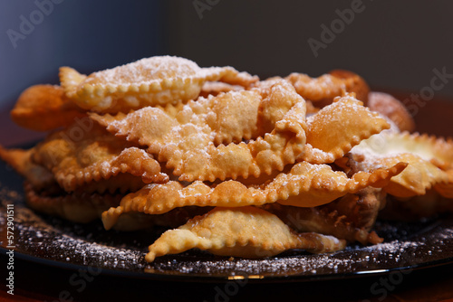 Frappe or chiacchiere and onbaked castagnole typical Italian carnival fritters dusted with powdered sugar. Biscuits with sugar for the carnival of Venice. Traditional sweet pastries photo