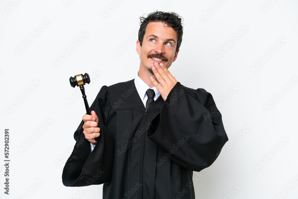 Young judge caucasian man isolated on white background looking up while smiling Young judge caucasian man isolated on white background looking up while smiling