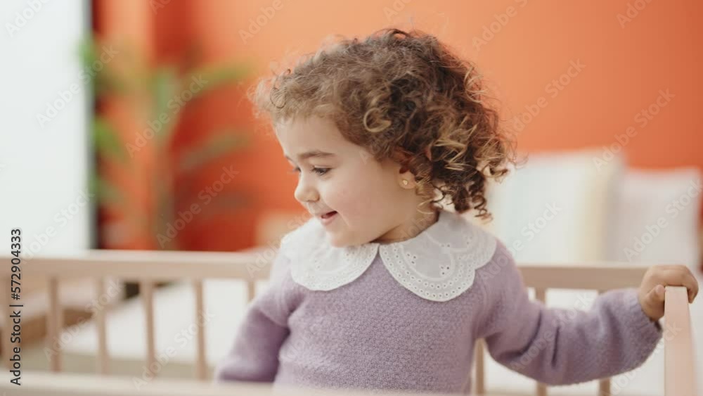 Adorable hispanic girl smiling confident standing on cradle at bedroom Adorable hispanic girl smiling confident standing on cradle at bedroom