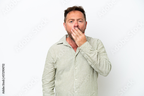 Middle age caucasian man isolated on white background yawning and covering wide open mouth with hand