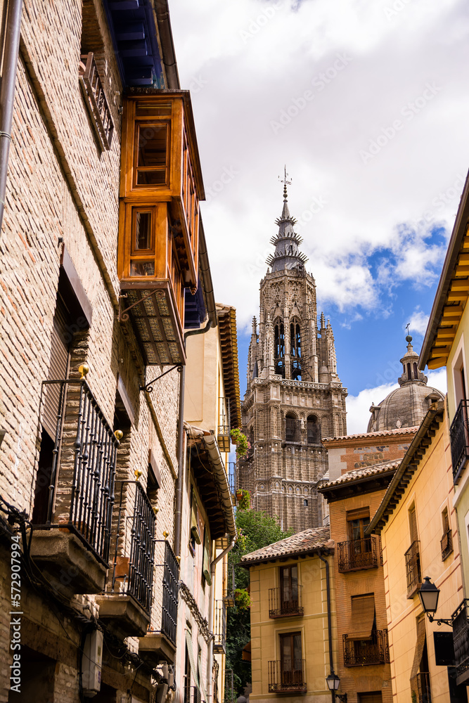 Narrow alleys of Toledo with shade cover and view of the bell tower of the cathedral