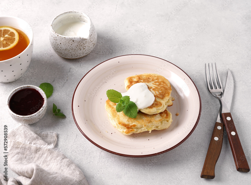 Sweet Pancakes with Cream, jam and tea. Health Breakfast, light bakground Sweet Pancakes with Cream, jam and tea. Health Breakfast, light bakground