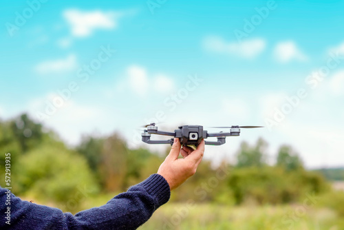 man using a drone with remote controller making photos and videos, having fun with new technology trends