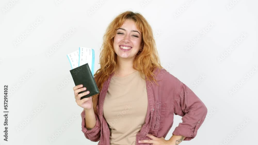Young redhead woman holding a boarding pass over isolated background Young redhead woman holding a boarding pass over isolated background