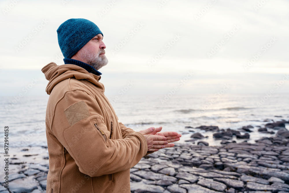 Bearded Man relaxing alone on the seaside on cold winter day. Travel Lifestyle concept Bearded Man relaxing alone on the seaside on cold winter day. Travel Lifestyle concept