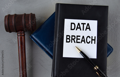DATA BREACH - word on a white sheet with leather notebooks, a judge's hammer and a pen