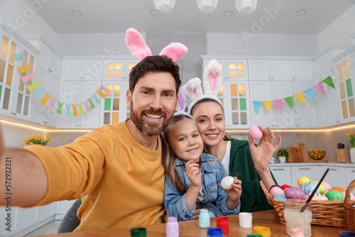 Canvas Print Happy family making selfie while painting Easter eggs in kitchen