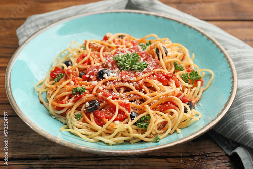 Delicious pasta with tomatoes  olives and parmesan cheese on wooden table  closeup