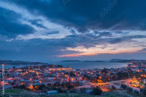 Seaside town with evening lights and blue sky with colorful clouds after sunset