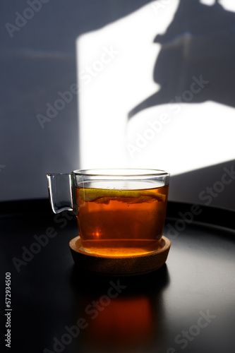 Lemon tea with teapot shade. teapot shadow.Hot drink concept with tea. tea drinking, morning ritual.