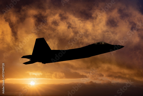 F-22 Raptor Fighter Jet on a combat mission. Sunset silhouette of fighter jet. F22 Raptor jet fighter warplane flying at sunset armed with sidewinders and missiles. Chinese spy balloon interceptor