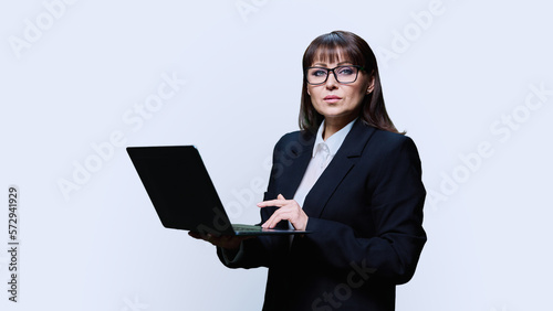 Mature business woman posing with laptop on white background photo