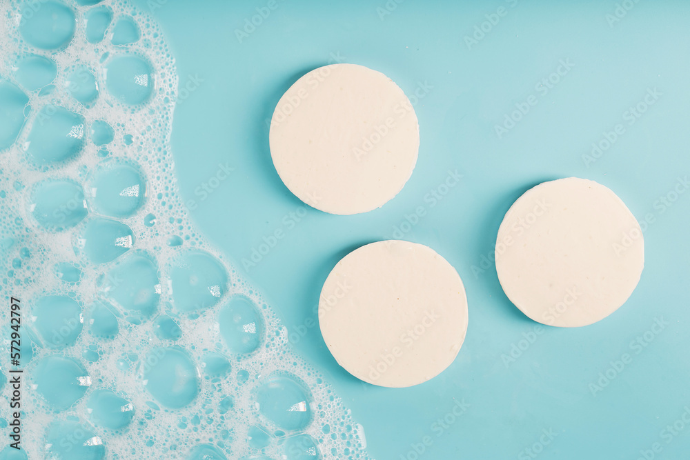 Three round pieces of white soap with foam - obrazy, fototapety, plakaty 