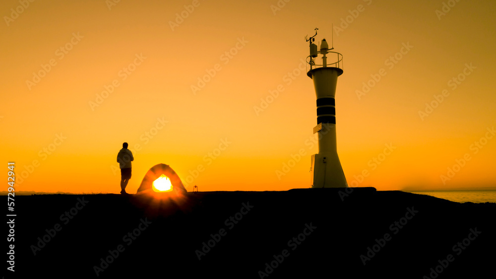 A man watching the sunset with his tent near the lighthouse. A man watching the landscape alone, solitude and sunset. Ordu, Türkiye