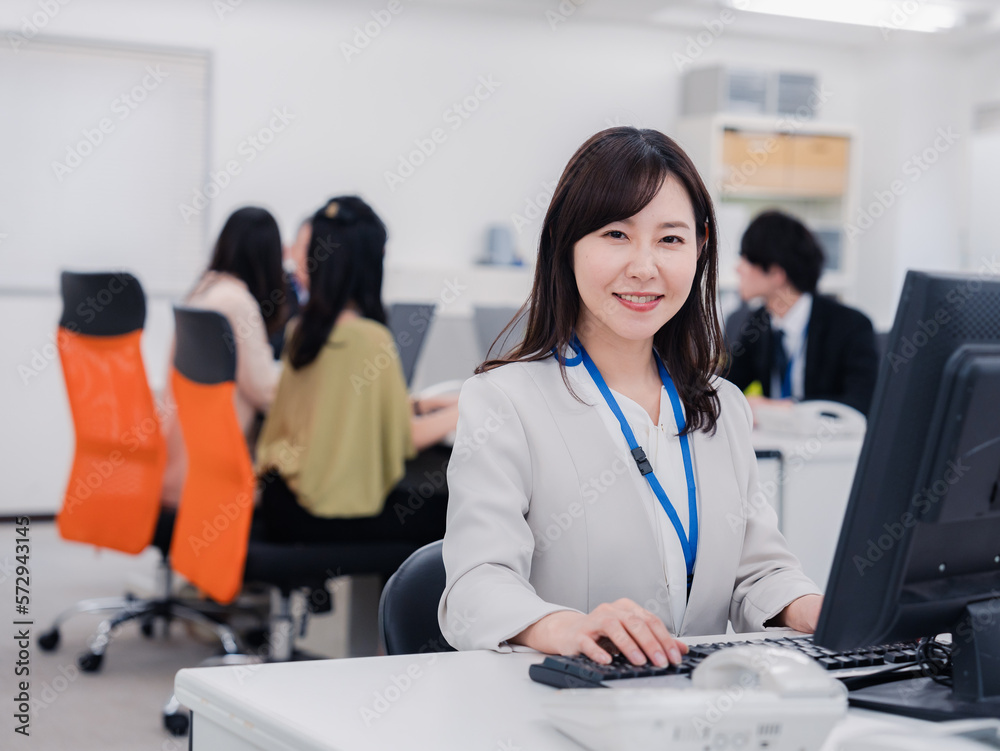笑顔でデスクワークをする女性 笑顔でデスクワークをする女性