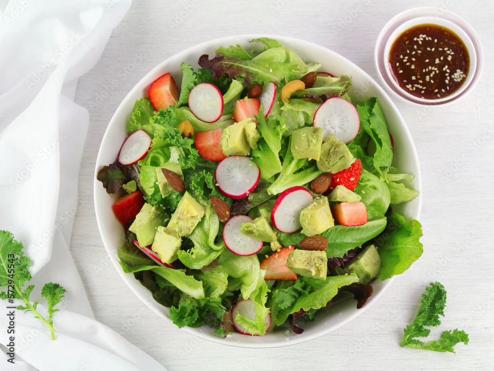 Green lettuce salad with fresh vegetables isolated on white background.