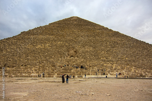 Tourists and locals walking around the Pyramid of Khufu, archaeological landmark in Giza, Egypt, Africa. 