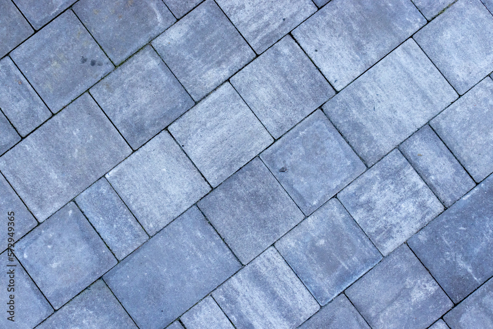 Gray paving stones road. Paving surface road. Texture made of big gray cement bricks Gray paving stones road. Paving surface road. Texture made of big gray cement bricks