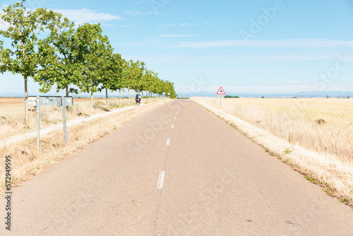 French Way - pilgrims walking the Camino halfway between El Burgo Ranero and Reliegos, province of Leon, Castile and Leon, Spain - June 2022 photo