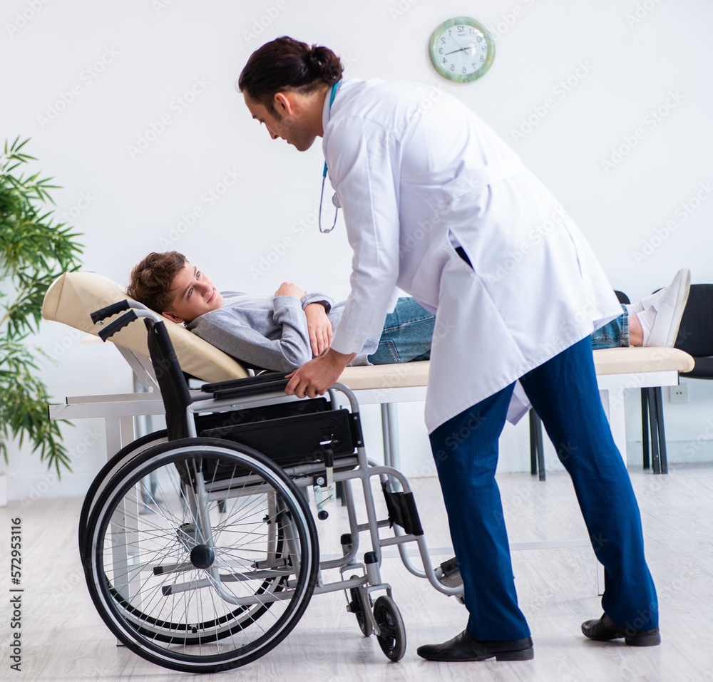 Young male doctor pediatrist and boy in wheel-chair