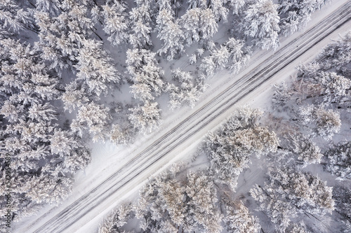 Aerial view of road in winter forest landscape © Ravil Sayfullin
