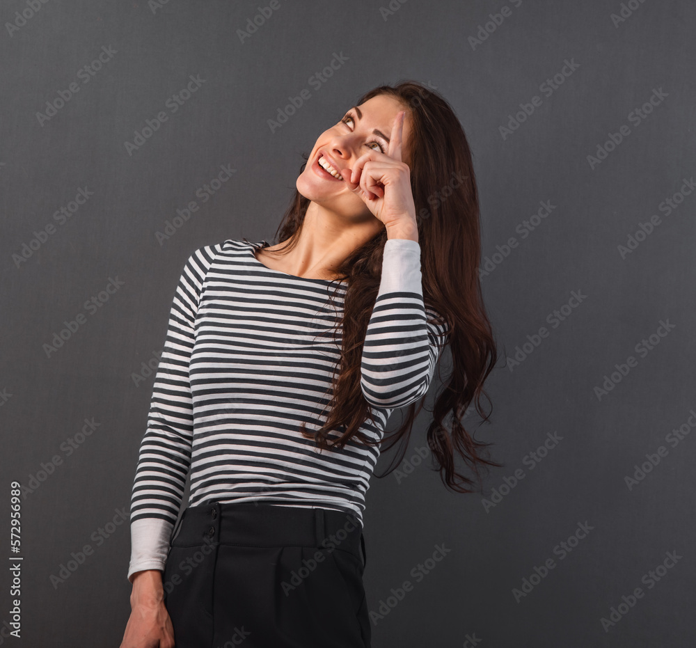 Portrait of beautiful happy smiling woman showing the finger up in casual clothing Portrait of beautiful happy smiling woman showing the finger up in casual clothing