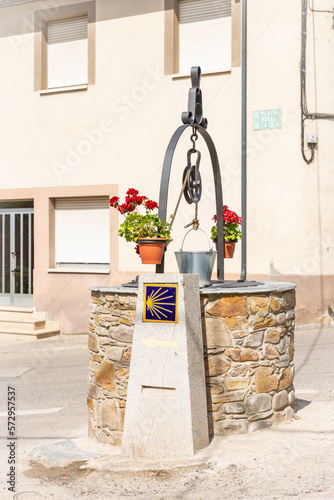 way of Saint James marker and a water well in Nogal de la Coja square at Toral de Merayo, municipality of Ponferrada, El Bierzo, province of León, Spain - June 2022  photo