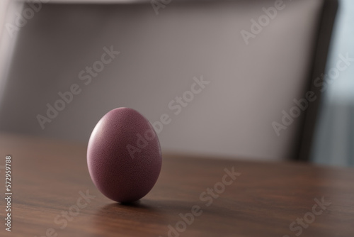Purple Easter egg on a wooden table with copy space