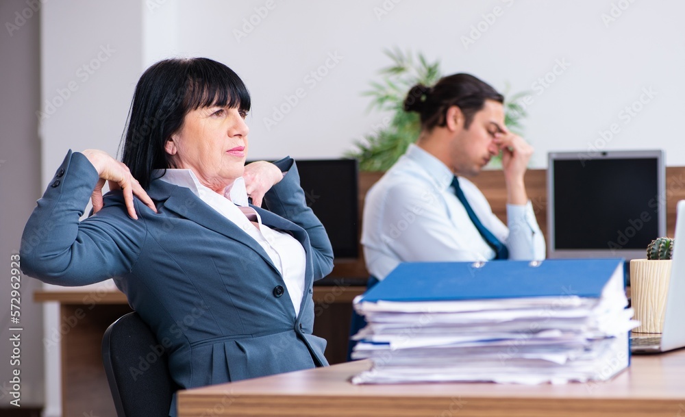 Two employees doing sport exercises in the office Two employees doing sport exercises in the office