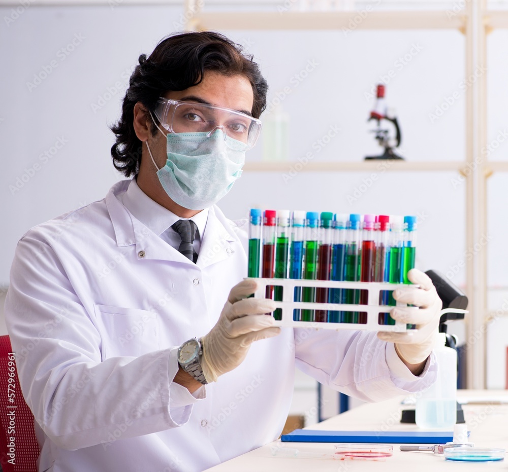 Young handsome chemist working in the lab Young handsome chemist working in the lab