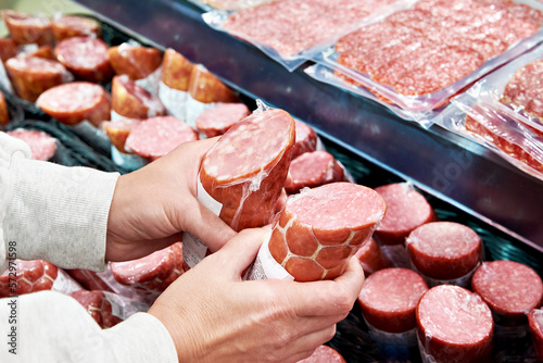Sliced sausage in hands in store