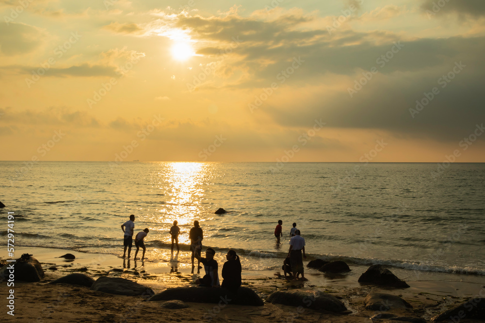 Fototapeta premium 夕焼けの海と人々