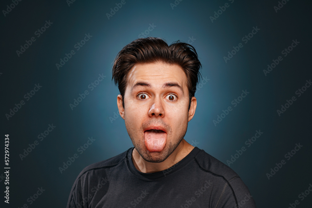 Young brunette man showing tongue emotional portrait