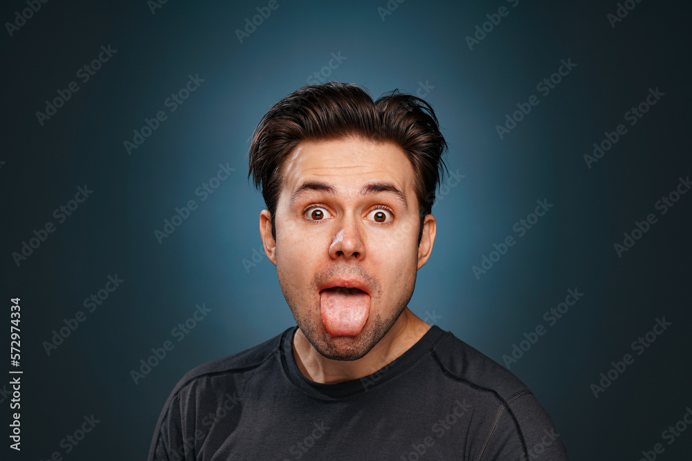 Fototapeta premium Young brunette man showing tongue emotional portrait