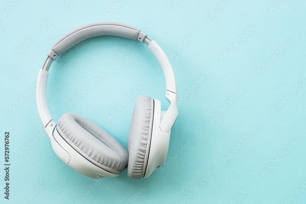 Wireless Headphones on blue background. Flat lay with copy space. Wireless Headphones on blue background. Flat lay with copy space.