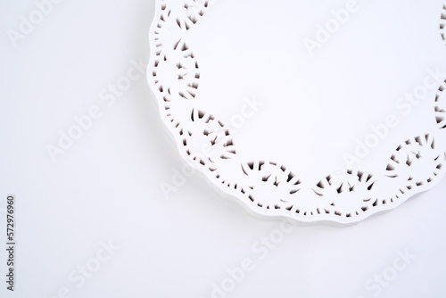 The round white napkin of frilly paper is isolated on white background, copy space. Macro shots