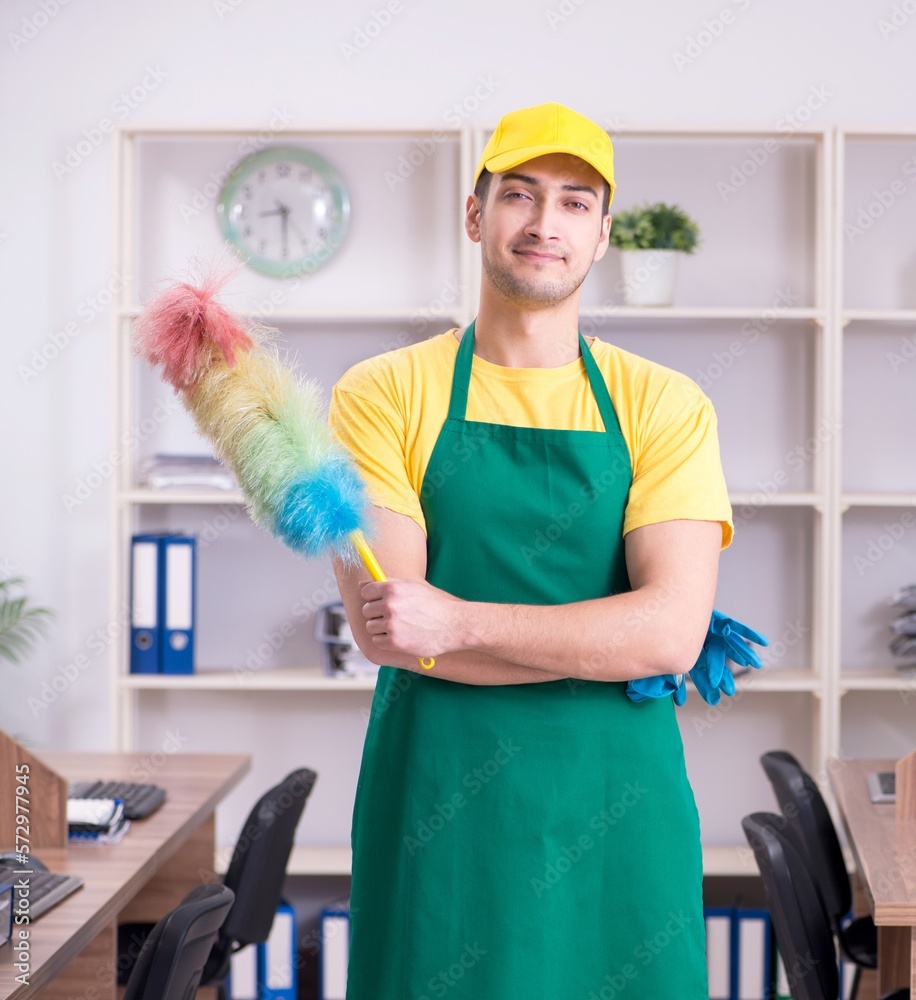 Young male contractor cleaning the office Young male contractor cleaning the office